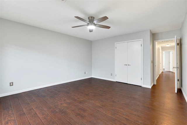 unfurnished bedroom with dark wood-style floors, a ceiling fan, baseboards, and a closet