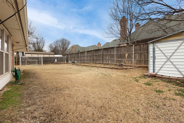 view of yard with a shed, an outdoor structure, and a fenced backyard