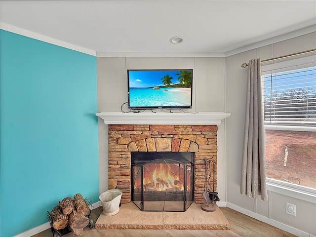 interior details with a fireplace, baseboards, and wood finished floors