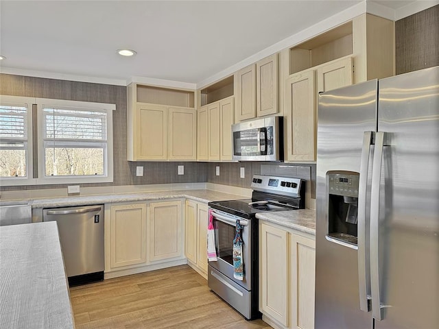 kitchen featuring backsplash, light wood-style flooring, stainless steel appliances, and light countertops