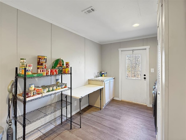 laundry area with light wood-type flooring, baseboards, visible vents, and a sink