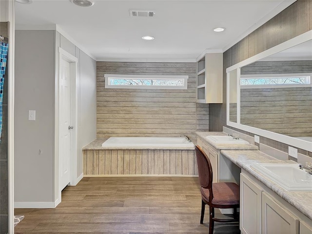 office with baseboards, visible vents, a sink, and wood finished floors