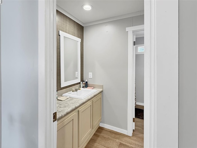 bathroom with baseboards, wood finished floors, and vanity