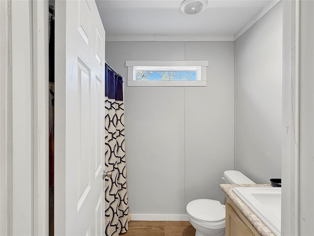 full bathroom with visible vents, a shower with shower curtain, toilet, vanity, and wood finished floors