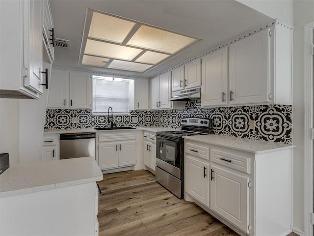 kitchen featuring range with electric cooktop, white cabinets, dishwasher, under cabinet range hood, and a sink