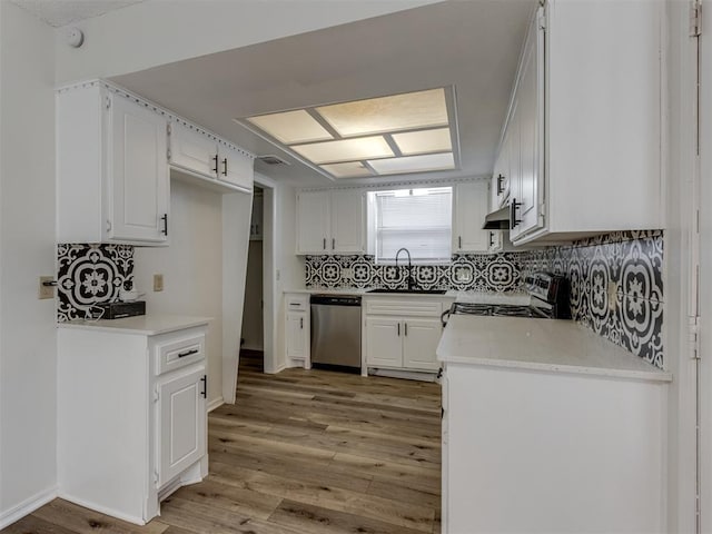 kitchen featuring under cabinet range hood, light wood-style flooring, appliances with stainless steel finishes, and a sink