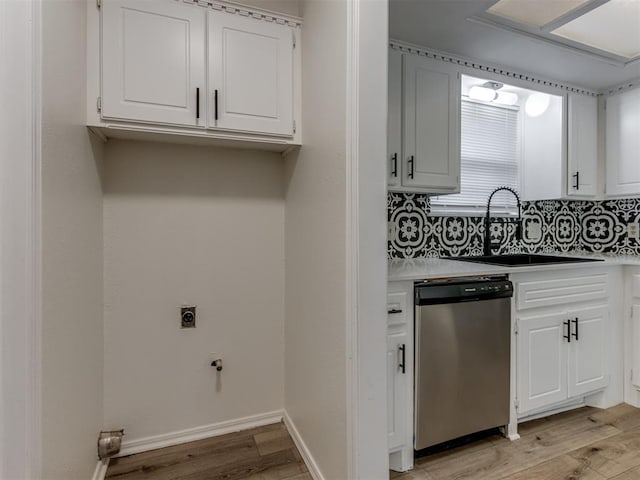 kitchen featuring a sink, light wood-style floors, white cabinetry, and stainless steel dishwasher