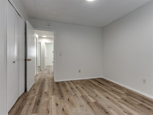 unfurnished room featuring baseboards and light wood-style floors