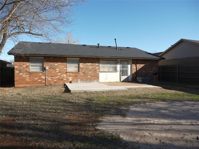 rear view of house with brick siding, a patio, central AC, and fence