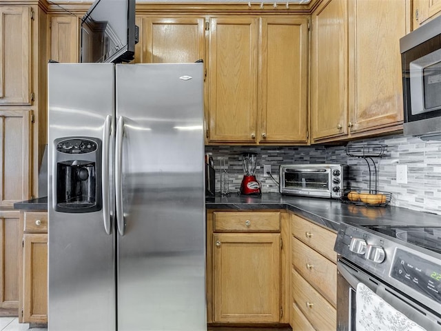 kitchen with appliances with stainless steel finishes, dark countertops, a toaster, and decorative backsplash