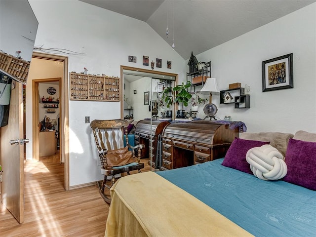 bedroom with lofted ceiling and light wood-style flooring