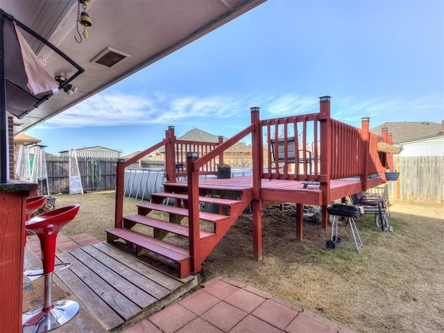 deck with a yard and a fenced backyard