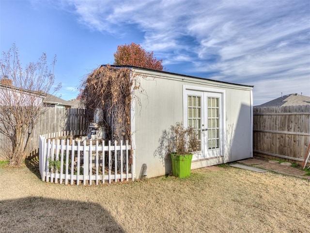 view of outdoor structure with french doors, an outdoor structure, and a fenced backyard