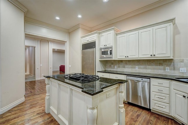 kitchen with light wood-type flooring, tasteful backsplash, and built in appliances