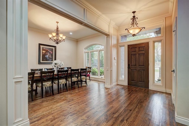 entrance foyer featuring baseboards, crown molding, an inviting chandelier, and wood finished floors