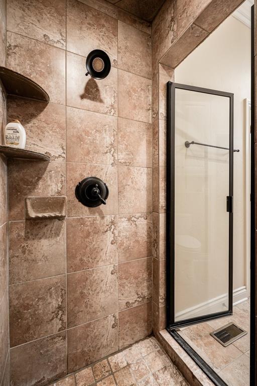 bathroom with a stall shower and visible vents