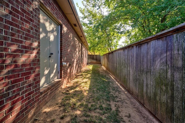 view of property exterior featuring brick siding and a fenced backyard