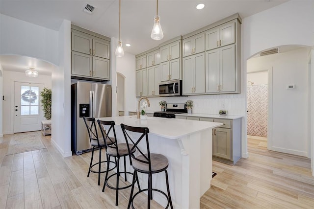 kitchen with visible vents, appliances with stainless steel finishes, and arched walkways