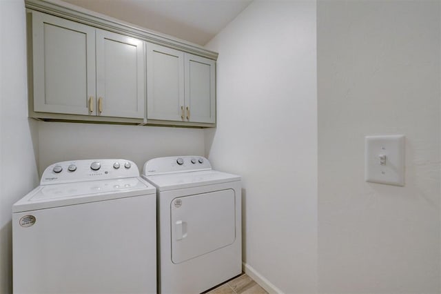 washroom with cabinet space, baseboards, and washer and dryer