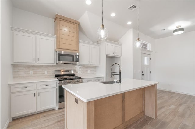 kitchen with tasteful backsplash, visible vents, light countertops, appliances with stainless steel finishes, and a sink