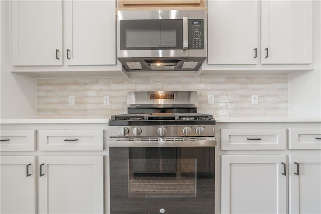 kitchen with backsplash, appliances with stainless steel finishes, white cabinets, and light countertops