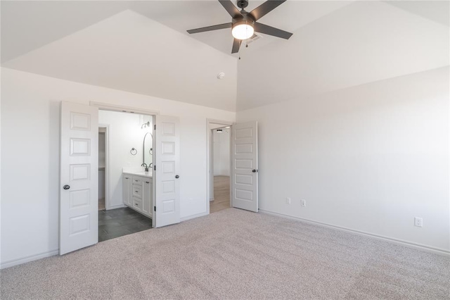 unfurnished bedroom with ensuite bath, vaulted ceiling, baseboards, and carpet floors