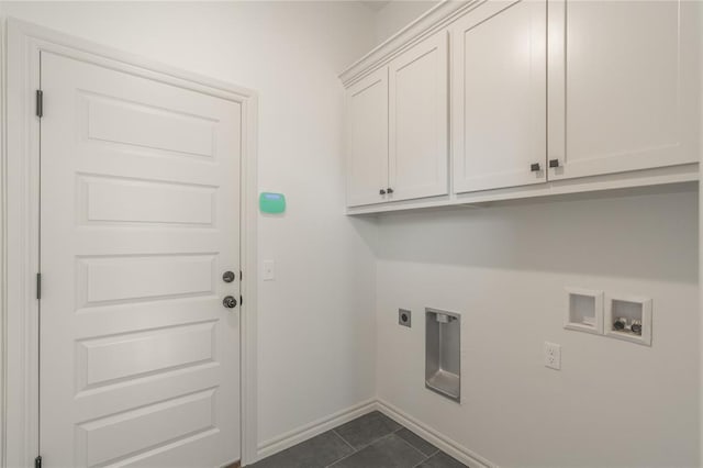 laundry room with electric dryer hookup, washer hookup, dark tile patterned floors, cabinet space, and baseboards