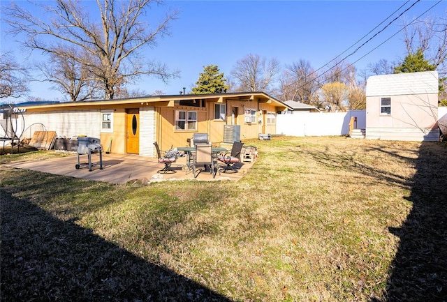 back of property featuring an outdoor structure, fence, a yard, a trampoline, and a patio area