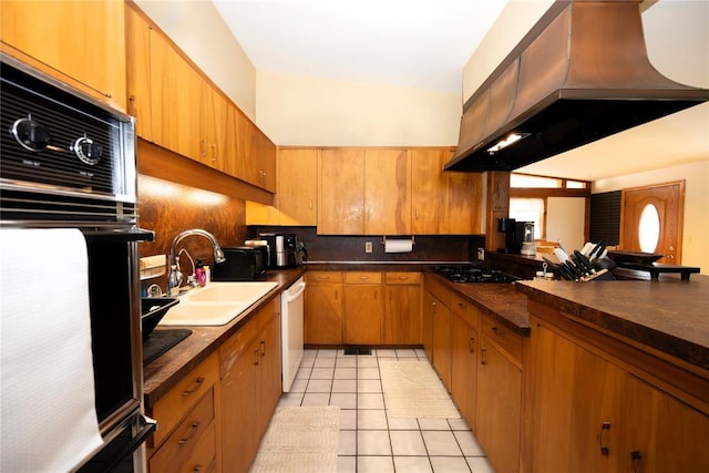 kitchen featuring range hood, light tile patterned floors, dark countertops, a sink, and black appliances