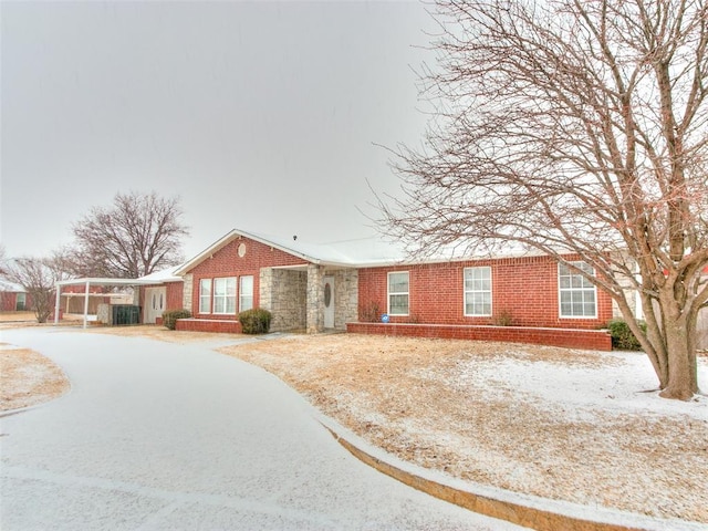 ranch-style house featuring driveway, brick siding, and cooling unit