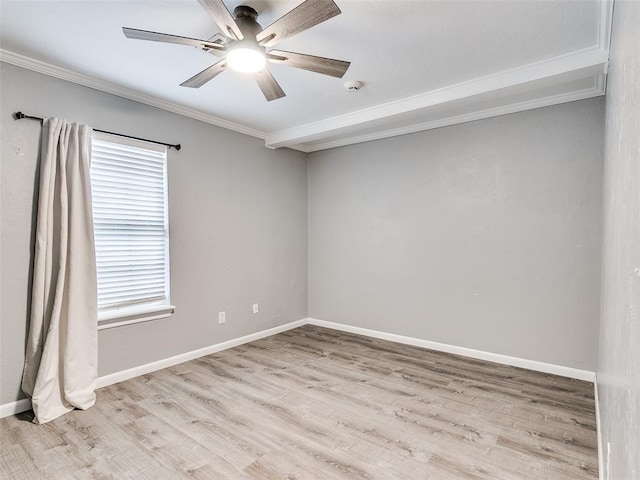 empty room with ceiling fan, light wood finished floors, crown molding, and baseboards