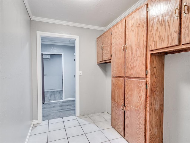 interior space featuring light tile patterned floors, baseboards, and crown molding