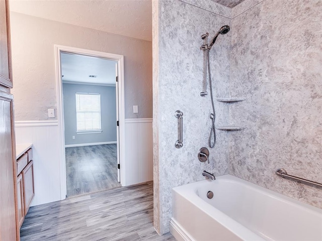 bathroom featuring shower / washtub combination, wainscoting, vanity, and wood finished floors