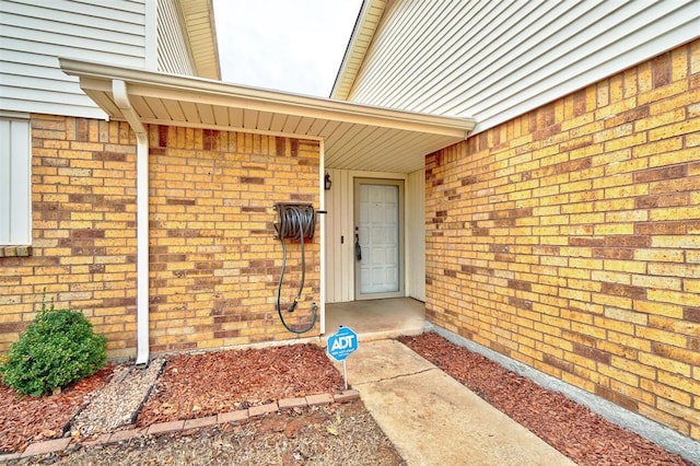 view of exterior entry featuring brick siding