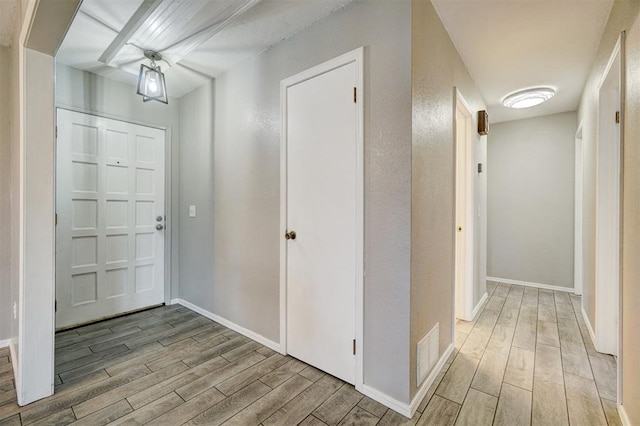 entrance foyer featuring baseboards, visible vents, and wood tiled floor