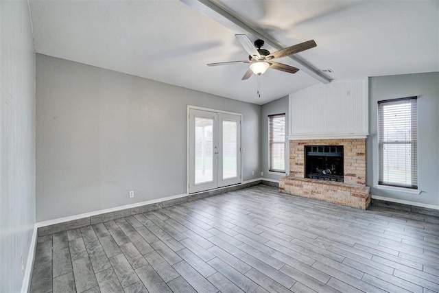 unfurnished living room with lofted ceiling with beams, plenty of natural light, and wood finished floors