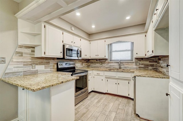 kitchen featuring a sink, white cabinets, appliances with stainless steel finishes, light stone countertops, and open shelves