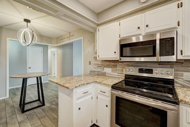 kitchen with stainless steel appliances, a peninsula, white cabinetry, and decorative backsplash