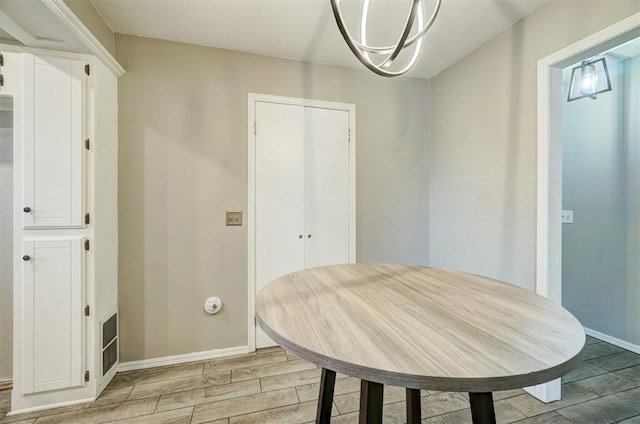 unfurnished dining area featuring light wood-type flooring and baseboards