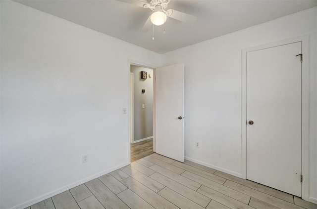 empty room featuring wood finish floors, ceiling fan, and baseboards