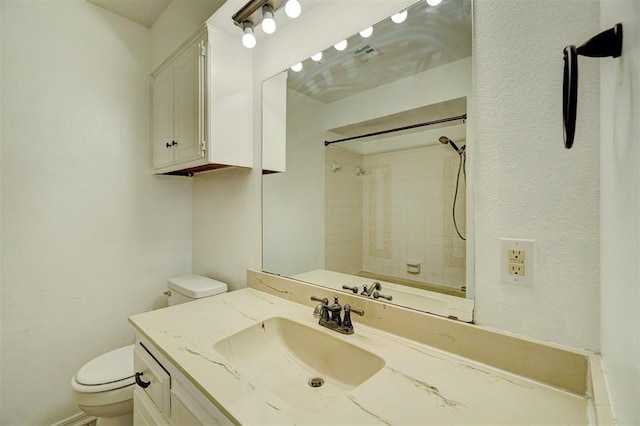 bathroom featuring visible vents, vanity, toilet, and walk in shower