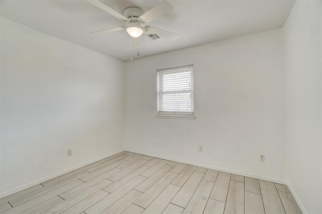 unfurnished room featuring light wood-style floors, visible vents, ceiling fan, and baseboards