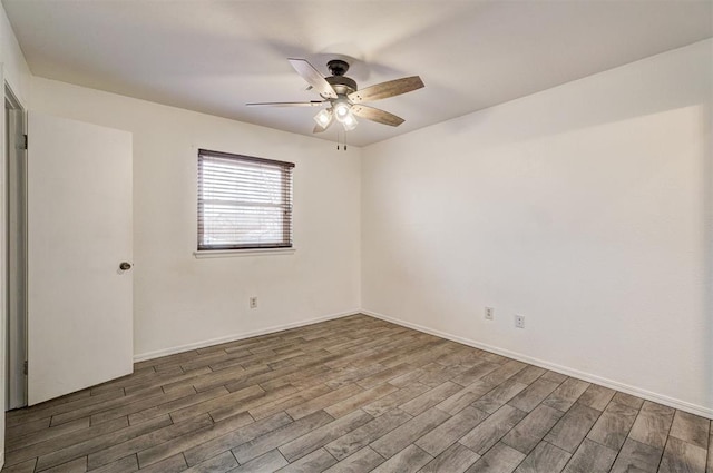 spare room featuring ceiling fan, baseboards, and wood finished floors