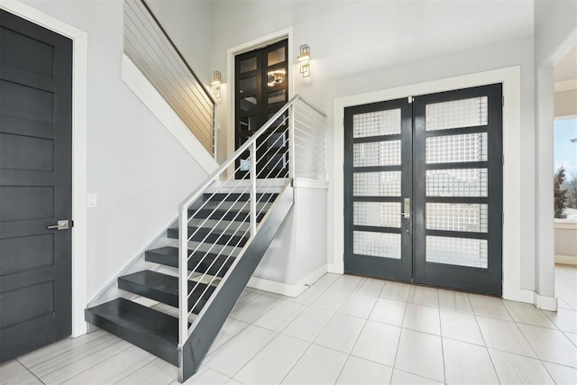 entryway featuring stairway, baseboards, and french doors