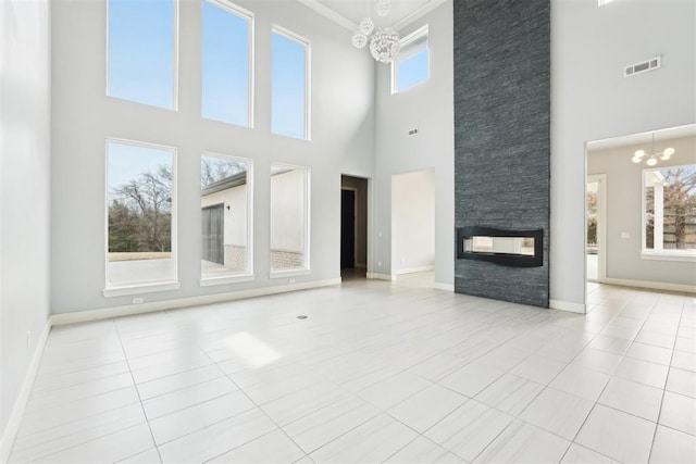 2725 Piazza Ct, Arcadia, OK 73007 - unfurnished living room featuring a chandelier, a towering ceiling, a fireplace, tile patterned floors, and crown molding