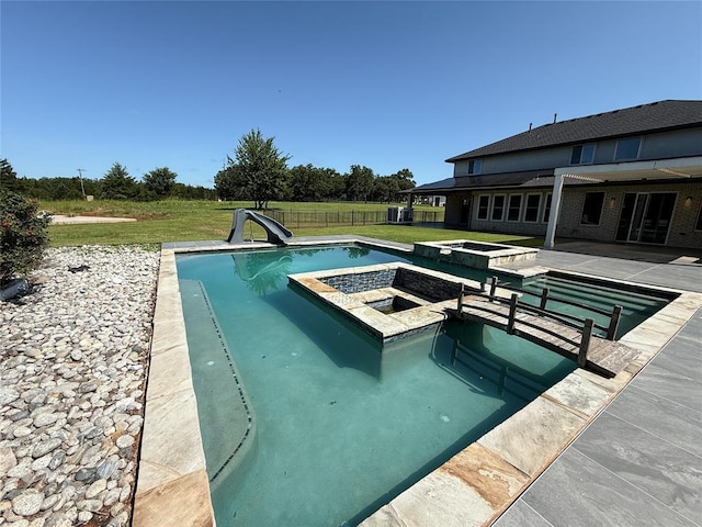 2725 Piazza Ct, Arcadia, OK 73007 - view of swimming pool featuring a water slide, a pool with connected hot tub, and a patio area