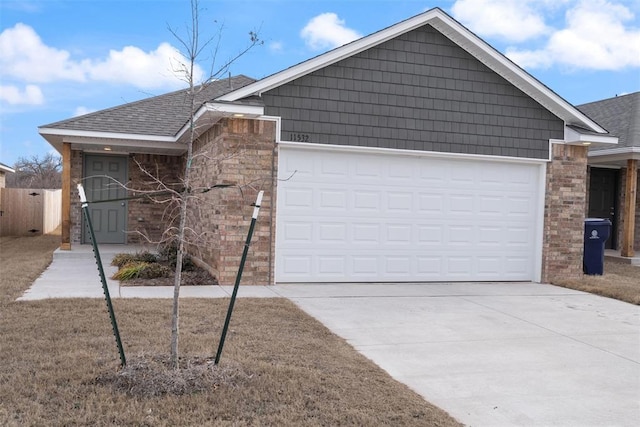 single story home with stone siding, concrete driveway, brick siding, and a garage