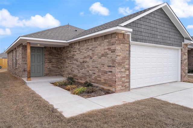 view of front of home with a garage, driveway, brick siding, and roof with shingles