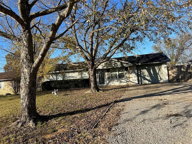 ranch-style house with an attached garage and fence