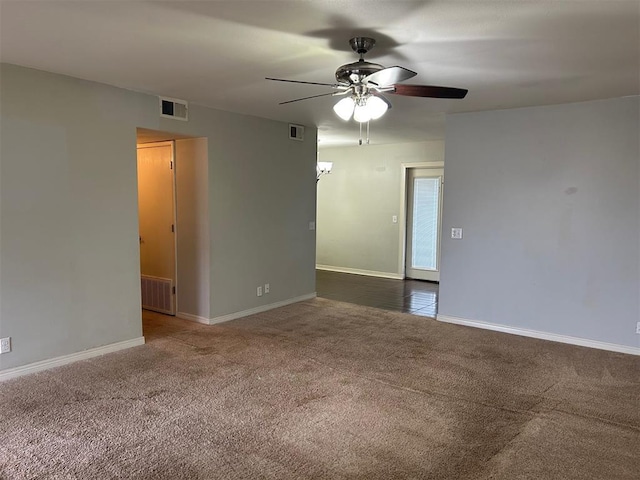 carpeted empty room featuring a ceiling fan, visible vents, and baseboards